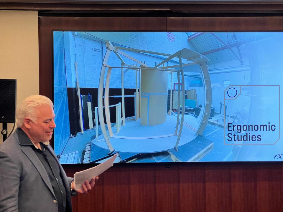 Frank Stephenson stands in front of a presentation which shows a construction model of the Halo Space capsule, at a press conference in London