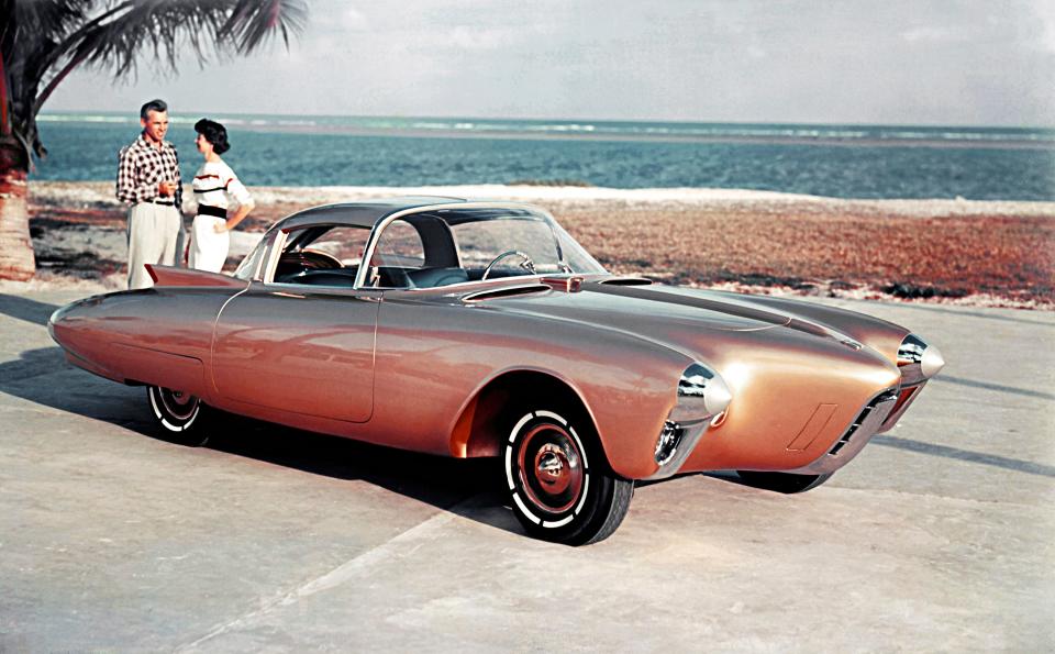 The Oldsmobile Golden Rocket was shown at the 1956 Motorama with a gold-colored fiberglass body, brilliant blue interior and aerodynamic styling.  The Golden Rocket (XP-400) possessed a look of both grace and swiftness. Although it was less than 50 inches tall, driver and passenger could easily enter and exit the vehicle. As one of the doors opened, a roof panel was raised, and the seat was elevated and rotated outward. To aid the driver's entry, the car also featured a folding steering wheel, which would release when two buttons were pressed. Golden RocketÕs front wheels were housed in "twin torpedo" pontoons flanking a slim aircraft-inspired streamlined engine enclosure.