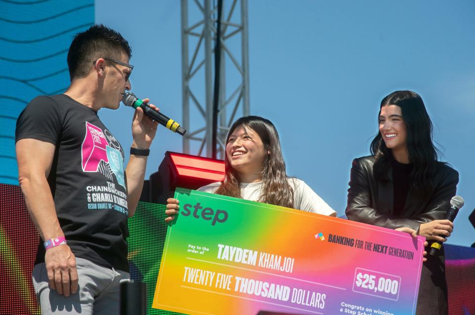 Step CEO JC MacDonald, left, and Tik Tok star Charli D'Amelio right, present a $25,000 scholarship to student Taydem Kahmjoi .