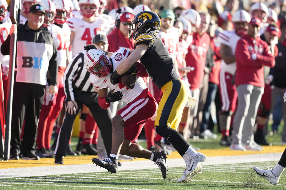 Nebraska wide receiver Alante Brown (4) is tackled by Iowa defensive back Cooper DeJean (3) after catching a pass during the first half of an NCAA college football game, Friday, Nov. 25, 2022, in Iowa City, Iowa. (AP Photo/Charlie Neibergall)