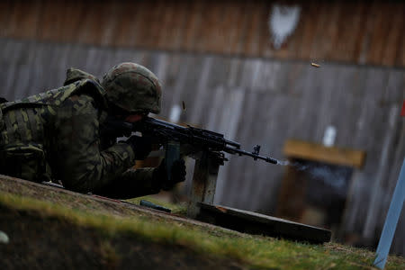 A recruit fires carbine during his 16-day basic training for Poland's Territorial Defence Forces, at a shooting range near Siedlce, Poland, December 7, 2017. REUTERS/Kacper Pempel/Files