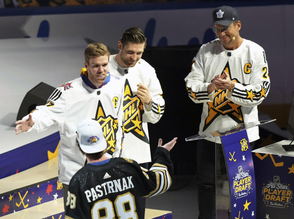 Connor McDavid, left, of Team McDavid picks David Pastrnak as Leon Draisaitl and Will Arnett, right, look on during the NHL All-Star hockey week draft in Toronto on Thursday, Feb. 1, 2024. (Nathan Denette/The Canadian Press via AP)