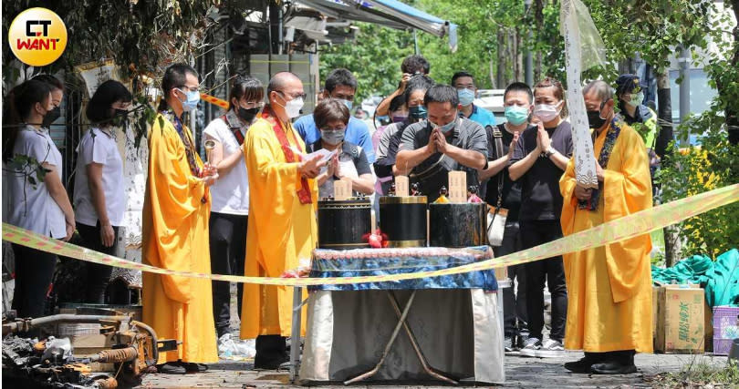 新竹正義輪胎行火災隔夜後，陳姓屋主與法師在現場為死去的八名親人招魂。(圖／張文玠攝）