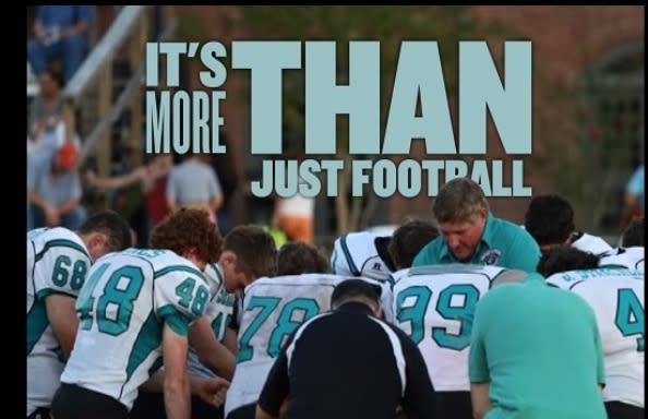 High school football coach Ronnie Mitchem (pictured in front of No. 99) was at the center of a national conversation over protest and the national anthem. (Photo via Victory & Praise Christian Academy) 