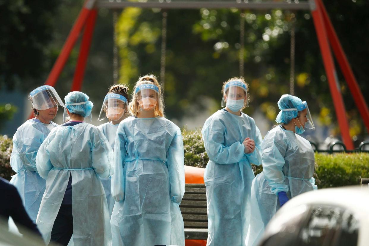 Workers are seen in personal protective equipment in Melbourne on Tuesday as the city returns to stage three lockdown restrictions: Getty Images