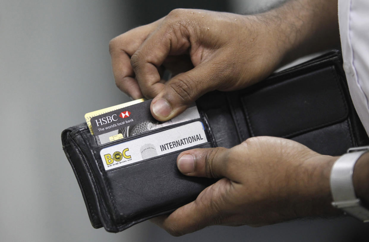 A man pulls out his credit card to make a purchase at a shop