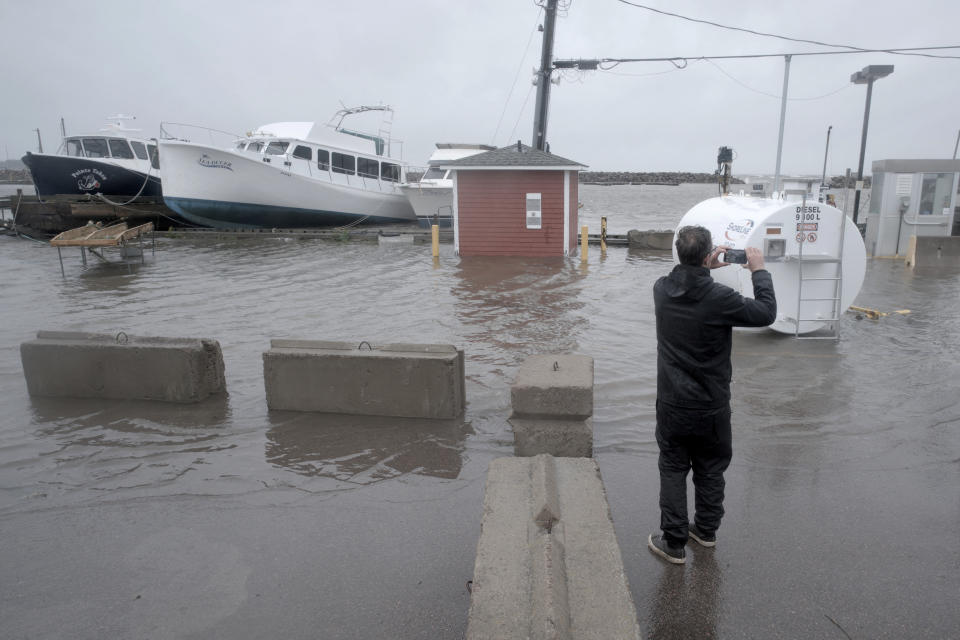 <p>A resident takes photographs of flooding following the passing of Hurricane Fiona, later downgraded to a post-tropical cyclone, in Shediac, N.B. on Sept. 24, 2022. (REUTERS/Greg Locke)</p> 