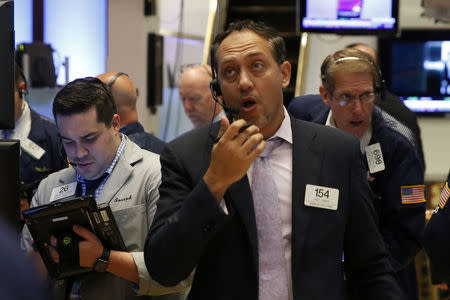 Traders work on the floor of the New York Stock Exchange (NYSE) shortly after the opening bell in New York, U.S., October 19, 2016. REUTERS/Lucas Jackson