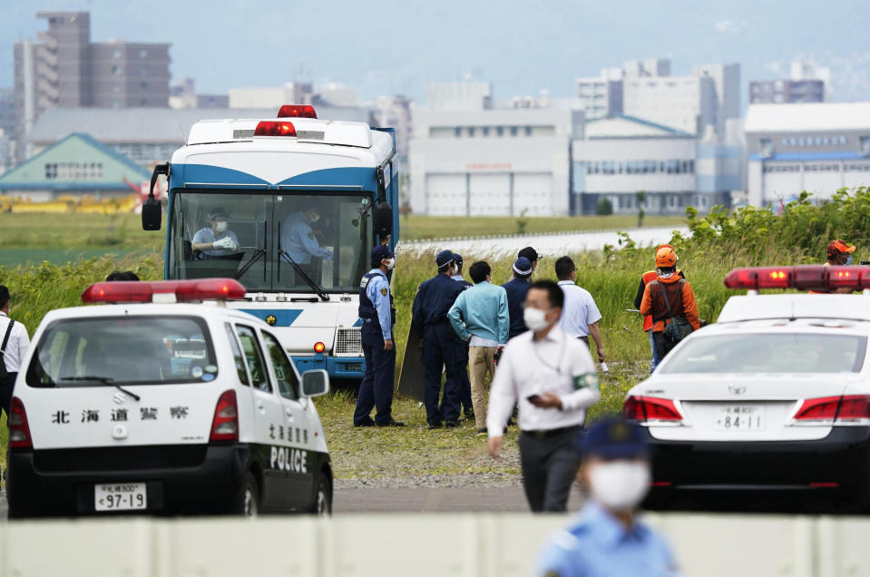 Police gather to look for a bear on the loose in Sapporo, northern Japan Friday, July 18, 2021. A wild brown bear on the loose all night in the city wounded four people, entered a military camp and disrupted flights at the airport Friday before being shot and killed by authorities. (Yohei Fukai/Kyodo News via AP)