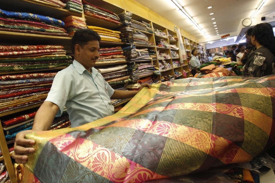 A vendor sells sari ahead of Deepavali at Little India in Singapore October 31, 2013. The Hindu community will celebrate the Festival of Lights known as Diwali or Deepavali, on November 2. REUTERS/Edgar Su (SINGAPORE - Tags: RELIGION BUSINESS TEXTILE)