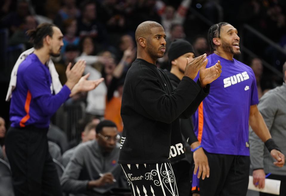 Suns guard Chris Paul claps on the bench during a game at Footprint Center in Phoenix on Jan. 21, 2023.