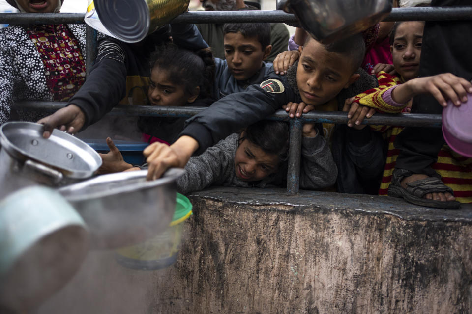 Palestinians line up for a free meal in Rafah, Gaza Strip, Friday, Feb. 16, 2024. International aid agencies say Gaza is suffering from shortages of food, medicine and other basic supplies as a result of the war between Israel and Hamas. (AP Photo/Fatima Shbair)