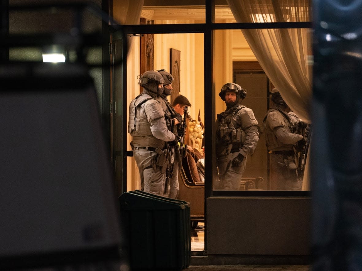 York Regional Police tactical officers are seen in the lobby of a condo building in Vaughan, Ont., Sunday, Dec. 18, 2022. A report by SIU has cleared a York officer in the fatal shooting of the suspected gunman who it says fatally shot five people in the building.  (Arlyn McAdorey/The Canadian Press - image credit)