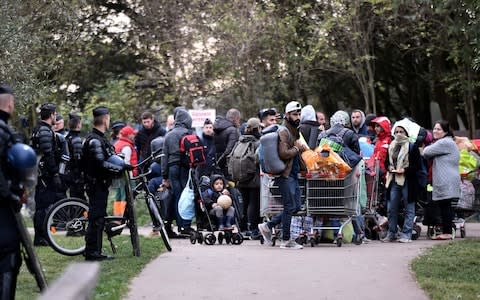 Migrants carry their belongings on October 23, 2018 during a police operation to evacuate a migrant camp in Grande Synthe, northwestern France. - Credit:  FRANCOIS LO PRESTI/AFP