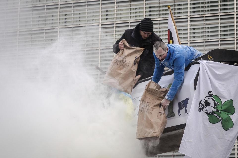 European dairy farmers spray the EU Council building with milk powder to protest the crisis in their sector, in Brussels on Monday, Jan. 23, 2017. The sector has been hit with sagging prices and production costs squeezing profits to the extent that has driven many farmers to the brink of bankruptcy. The EU's executive Commission has approved some support measures over the past year, but the farmers fear that releasing more milk powder on the market would further complicate their plight. (AP Photo/Geert Vanden Wijngaert)