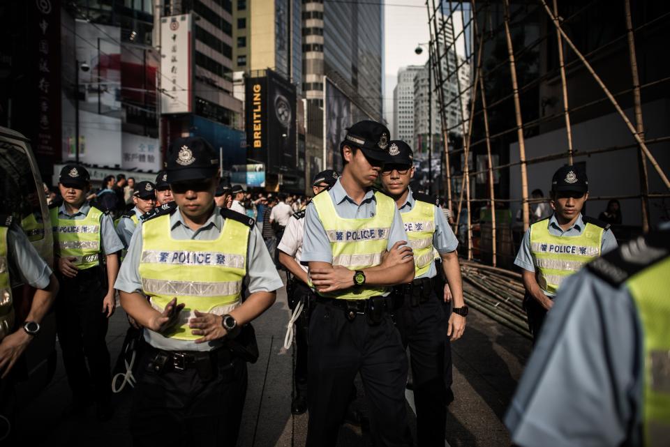 Policemen walk away from a scene where anti demonstrators confronted pro-democracy demonstrators in an occupied area of Hong Kong on October 3, 2014. (PHILIPPE LOPEZ/AFP/Getty Images)