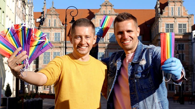 Gay couple Dawid Mycek and Jakub Kwiecinski pose with the rainbow-patterned face masks on a street in Gdansk