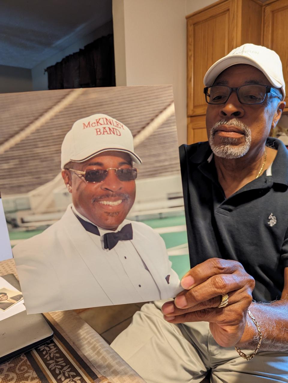 The Rev. Dr. Edward Arrington II of Canton shows a picture from his days as band director at McKinley High School. He recently earned a second doctorate at age 72.