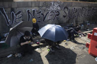 Pro-democracy protesters take rest on a bridge outside the Chinese University campus in Hong Kong, Wednesday, Nov. 13, 2019. Police increased security around Hong Kong and its university campuses as they brace for more violence after sharp clashes overnight with anti-government protesters. (AP Photo/Ng Han Guan)