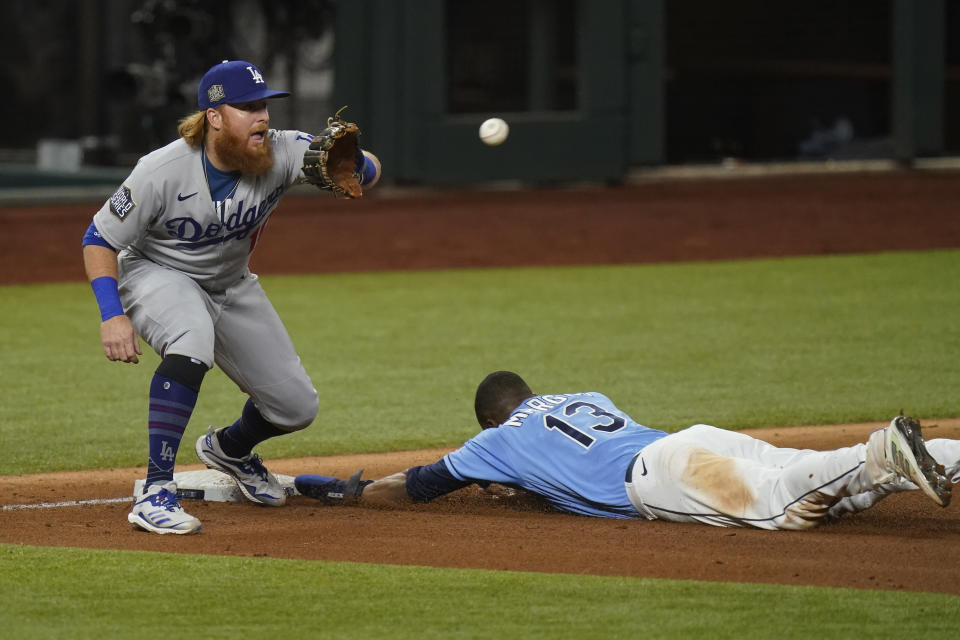 Tampa Bay Rays' Manuel Margot is safe at third past Los Angeles Dodgers third baseman Justin Turner after a Los Angeles Dodgers fielding error by Chris Taylor during the fourth inning in Game 5 of the baseball World Series Sunday, Oct. 25, 2020, in Arlington, Texas. (AP Photo/Eric Gay)