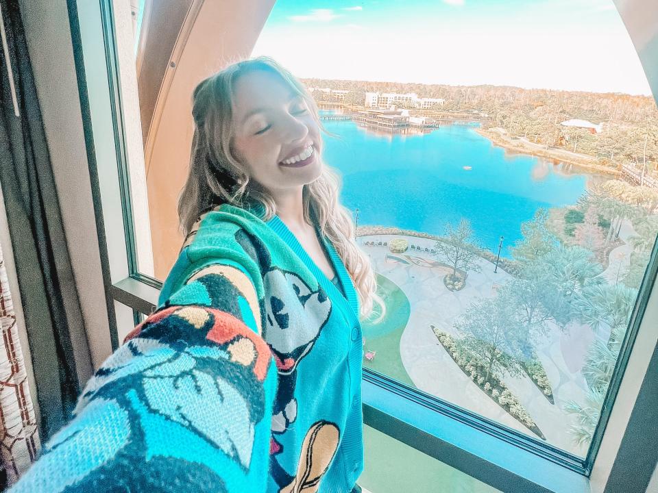 kayleigh posing in front of a window in a hotel room at disney's coronado springs resort