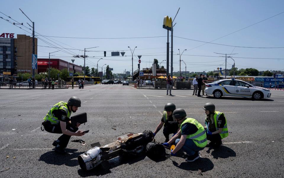 Ukrainian Police officers inspect a fragment of the rocket - Evgeniy Maloletka/AP