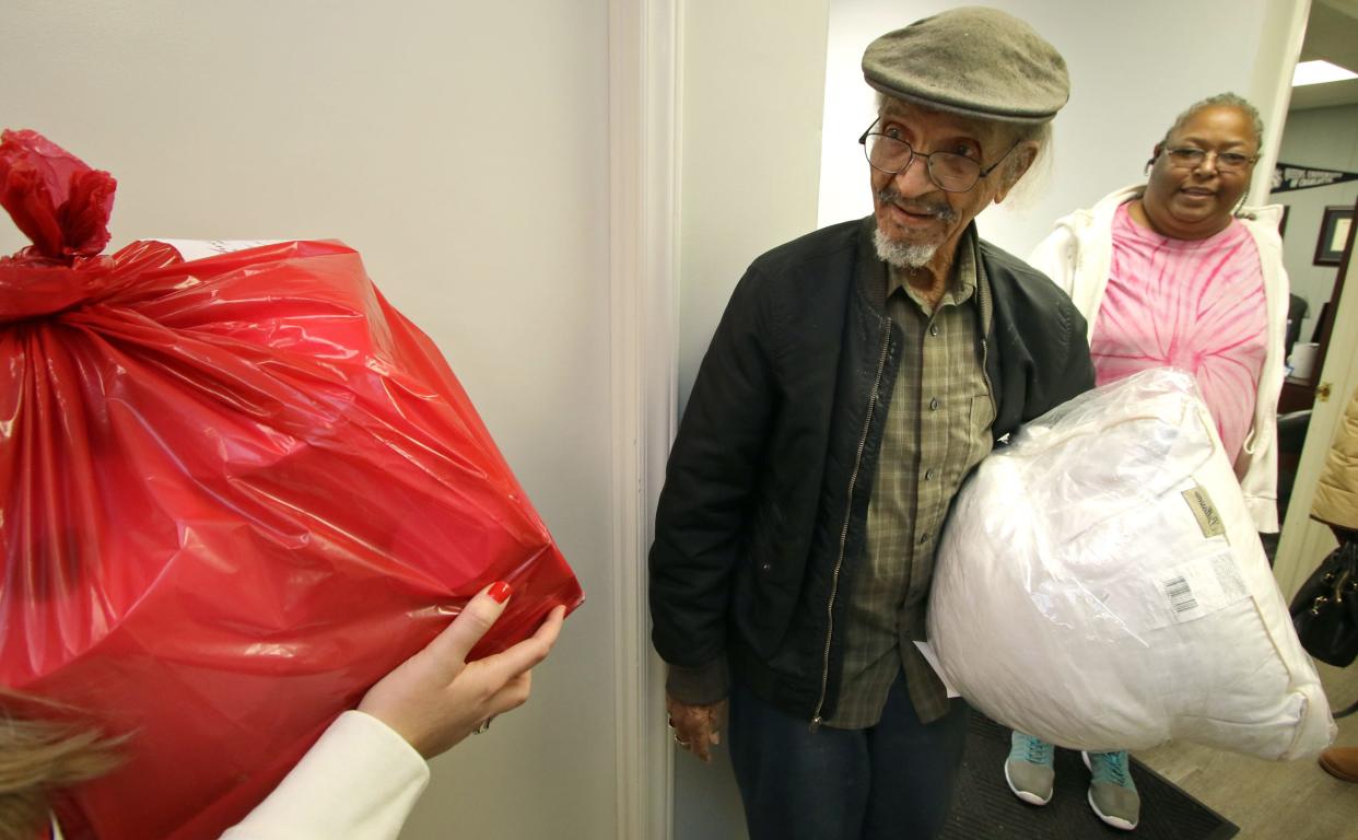 100-year-old James Petty smiles as he is given items for the Senior Christmas Wish program at the United Way offices on East Franklin Boulevard Tuesday morning, Dec. 12, 2023.