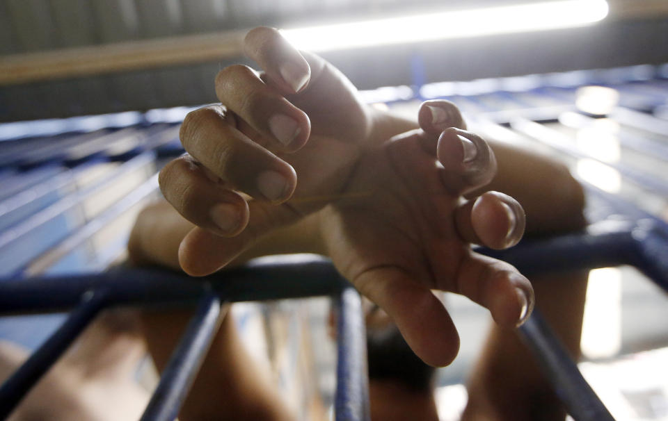 Detainees hang his hand at exercise in Bangkok immigration detention center in Bangkok, Thailand, Monday, Jan. 21, 2019. Advocates for the protection of refugees and asylum seekers lauded a commitment by Thailand on Monday to release children held in its immigration detention centers. (AP Photo/Sakchai Lalit)