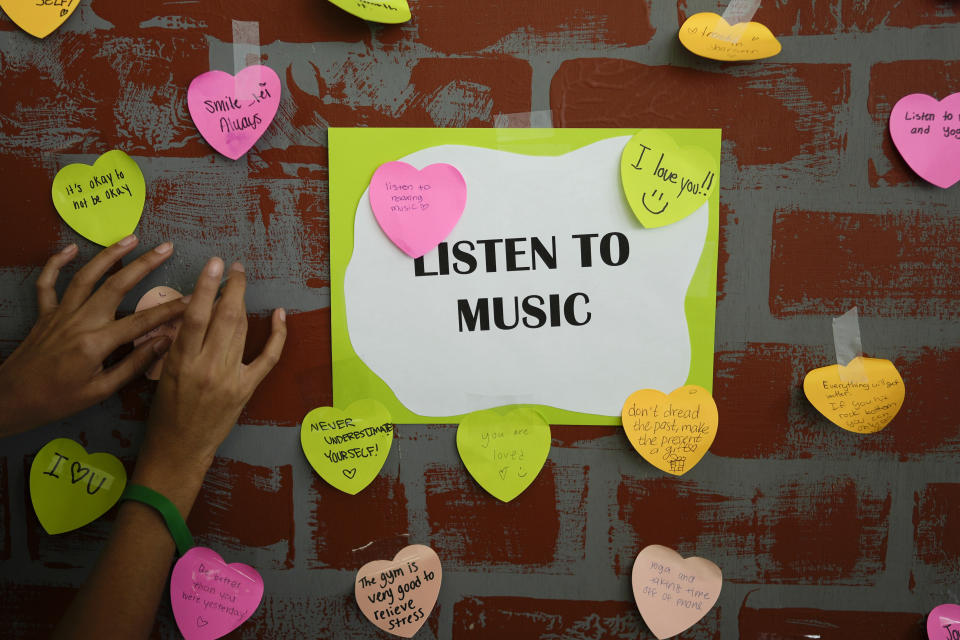 A student adds a note to others expressing support and sharing coping strategies, as members of the Miami Arts Studio mental health club raise awareness on World Mental Health Day, Tuesday, Oct. 10, 2023, at Miami Arts Studio, a public 6th-12th grade magnet school, in Miami. (AP Photo/Rebecca Blackwell)