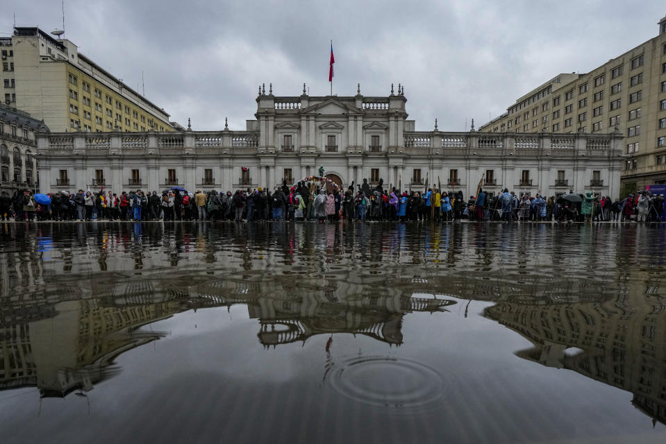 Miembros de la Asociación de Familiares de Detenidos Desaparecidos sostienen recortes de cartón que representan a sus familiares desaparecidos durante una marcha que conmemora la llamada "Operación Colombo", en la que más de 100 disidentes fueron ejecutados por las fuerzas de seguridad de la dictadura del general Augusto Pinochet en Santiago, Chile, el sábado 22 de julio de 2023. (AP Foto/Esteban Felix)