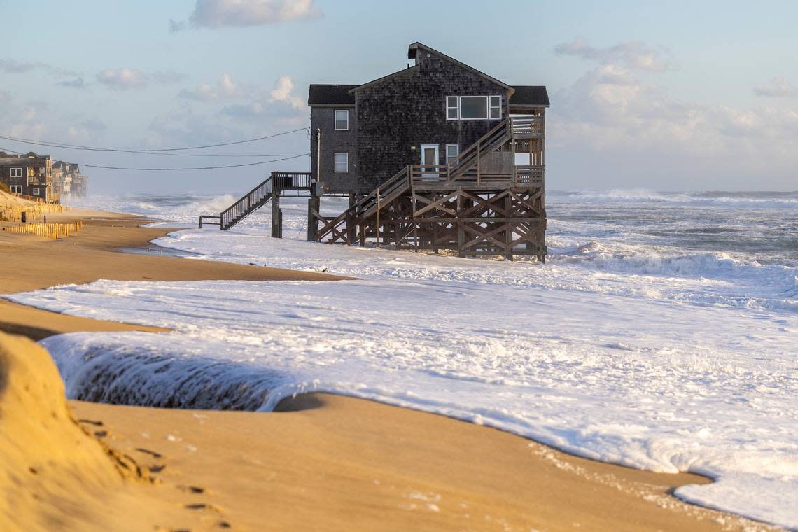 A home sits in the surf in Rodanthe in September 2023 as Hurricane Lee churns in the Atlantic. The federal government recently bought two threatened houses in Rodanthe to test whether that’s a viable way to prevent more from falling into the ocean. Travis Long/tlong@newsobserver.com