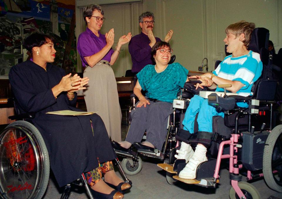 Judy Heumann, center, is applauded during her swearing-in as U.S. Assistant Secretary for Special Education and Rehabilitative Service by Judge Gail Bereola, left, in Berkeley, Calif., on June 29, 1993. Heumann, a renowned disability rights activist, passed away on Saturday at age 75.