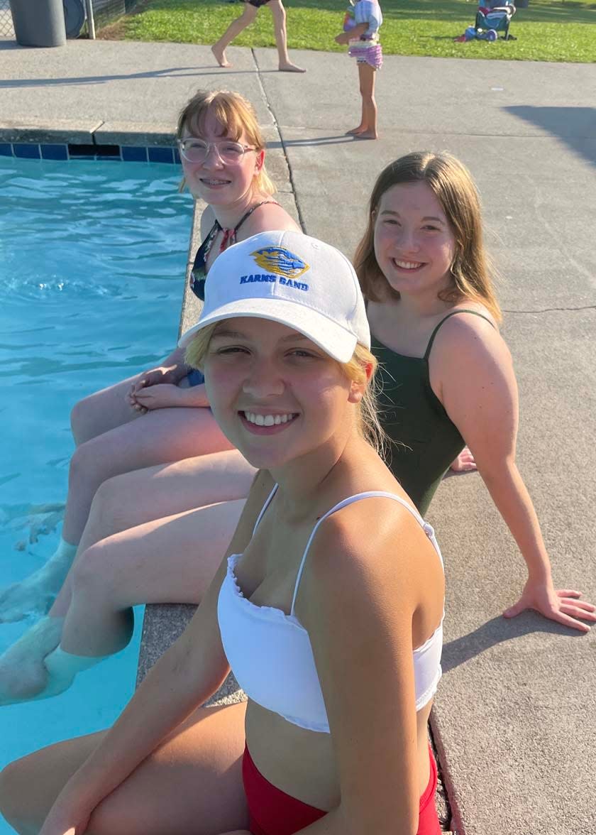 Avery Hanson, Amelia Brown and Grace Hunt, all 16, cool off by the pool at the summer pool party hosted by Beaver Ridge United Methodist Church at the Karns Lions Club Community Pool Saturday, July 16, 2022.