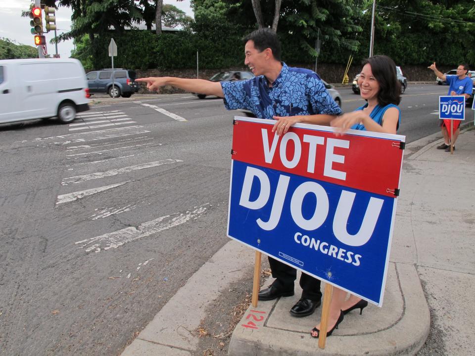 Republican Charles Djou and his wife Stacey wave at passing motorists in an attempt to pick up additional votes in his race for the U.S. House seat in Honolulu, Hawaii on Monday, Nov. 3. 2014. Djou is in a close race with Democratic state Rep. Mark Takai for the seat that will be left vacant by U.S. Rep. Colleen Hanabusa.