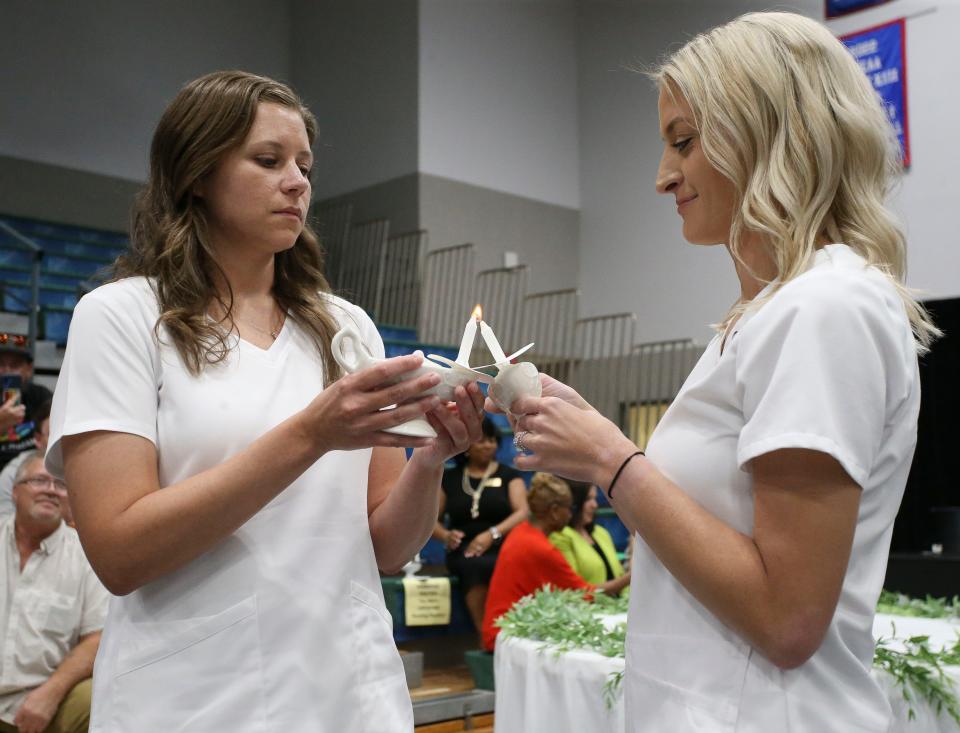 Nursing graduates participate in the lighting of the lamp ceremony during the nurse pinning and lamp ceremony Thursday, Aug. 3, 2023, at Shelton State.