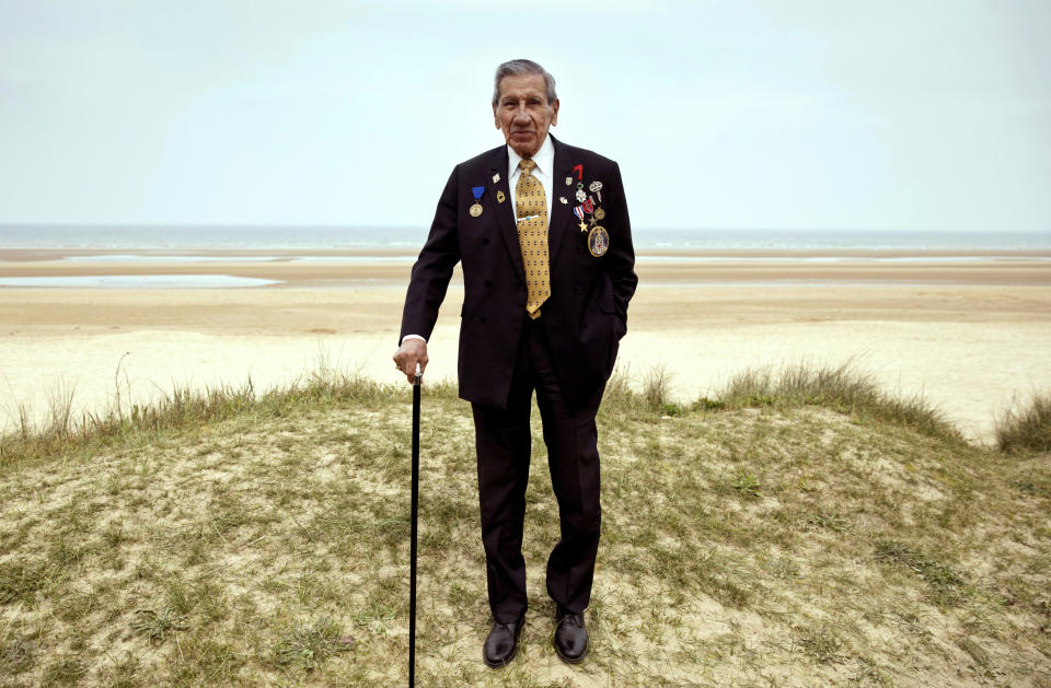 In this Wednesday, May 1, 2019 file photo, World War II and D-Day veteran Charles Norman Shay, from Maine, poses at the Charles Shay monument on Omaha Beach in Normandy, France. Instead of parades, remembrances, embraces and one last great hurrah for veteran soldiers who are mostly in their nineties to celebrate VE Day, it is instead a lockdown due to the coronavirus, COVID-19. (AP Photo/Virginia Mayo, File)