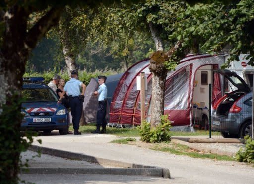 French police talk with investigators near the caravan of the British family killed on September 6 in the Alpine village of Saint-Jorioz. Investigators into the murders were pinning their hopes Friday on the seven-year-old girl wounded in the attack, as their probe appeared to make little headway