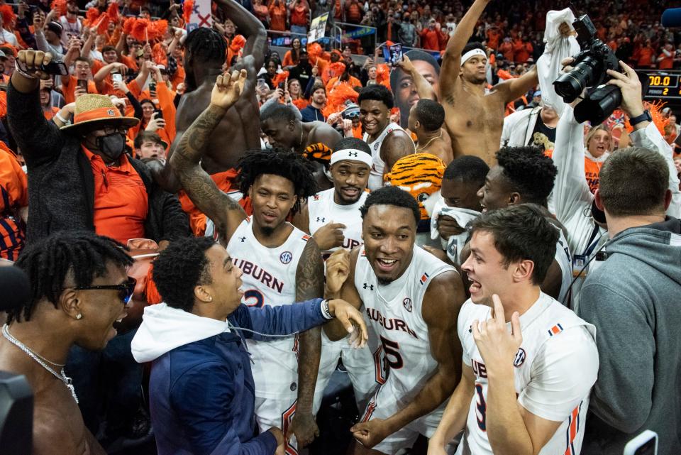 Auburn players celebrate with the student section as Auburn Tigers men's basketball takes on Kentucky Wildcats at Auburn Arena in Auburn, Ala., on Saturday, Jan. 22, 2022. Auburn Tigers defeated Kentucky Wildcats 80-71.