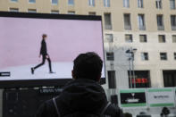 A giant screen streams a Prada fashion live show during the Milan's fashion week in Milan, Italy, Sunday, Jan. 17, 2021. (AP Photo/Luca Bruno)