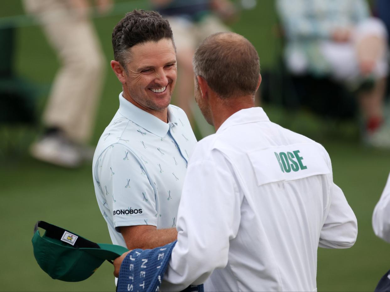 Justin Rose of England fist bumps his caddie, David Clark (Getty Images)
