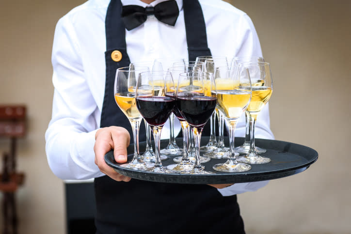 server holding a tray of wine