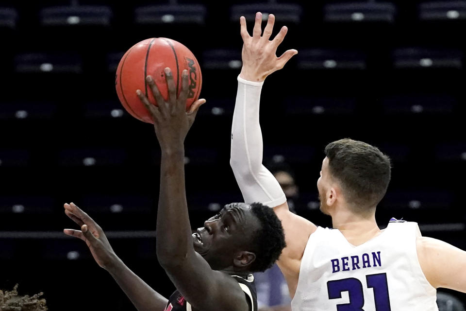 Nebraska forward Lat Mayen, left, drives to the basket past Northwestern forward Robbie Beran during the first half of an NCAA college basketball game in Evanston, Ill., Sunday, March 7, 2021. (AP Photo/Nam Y. Huh)