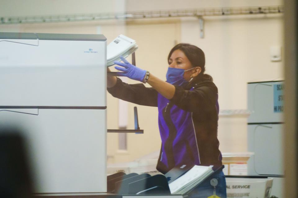 A tabulator technician participates in counting early voter mail-in ballots at the Maricopa County Tabulation and Election Center on Aug. 1, 2022, in Phoenix, Ariz.