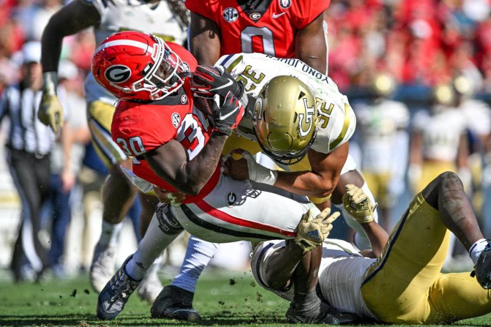 Georgia running back Daijun Edward gets wrapped up by the a couple of Georgia Tech defenders after making first down yardage Saturday as the Dawgs beat the Yellow Jackets 37-14.