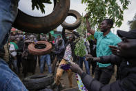 Kenyan opposition leader Raila Odinga's supporters ready tyres to be burnt as they celebrate developments at the electoral commission in the Kibera neighborhood of Nairobi, Kenya, Monday, Aug. 15, 2022. Kenyans are still waiting for the results of the presidential election in which they chose between Odinga and Deputy President William Ruto to succeed President Uhuru Kenyatta after a decade in power. (AP Photo/Ben Curtis)