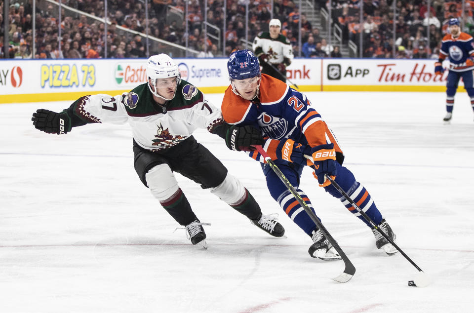 Arizona Coyotes' Victor Soderstrom (77) and Edmonton Oilers' Klim Kostin (21) battle for the puck during the second period of an NHL hockey game in Edmonton, Alberta, Wednesday, March 22, 2023. (Jason Franson/The Canadian Press via AP)