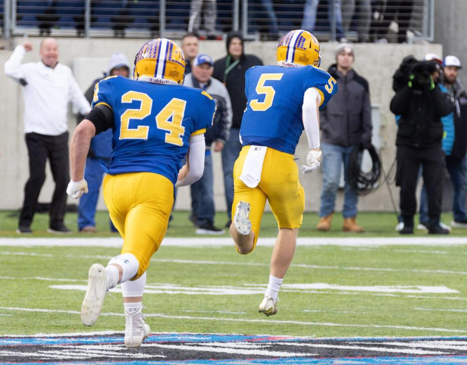 Marion Local’s Nathan Buschur (5) returns an interception 57 yards for a touchdown against Kirtland during the third quarter of the Division VI state final, Saturday, Dec. 3, 2022, at Tom Benson Hall of Fame Stadium.