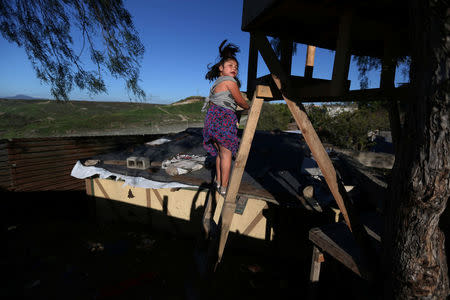 A girl climbs stairs near a section of the fence separating Mexico and the United States, in Tijuana, Mexico. REUTERS/Edgard Garrido