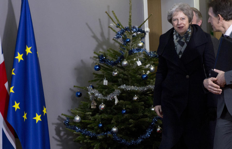 La primera ministra de Gran Bretaña, Theresa May (centro), pasa junto a un árbol de Navidad a la salida del edificio Europa, sede de la UE, tras reunirse con el presidente del Consejo Europeo, Donald Tusk, en Bruselas, el 11 de diciembre de 2018. (AP Foto/Virginia Mayo)