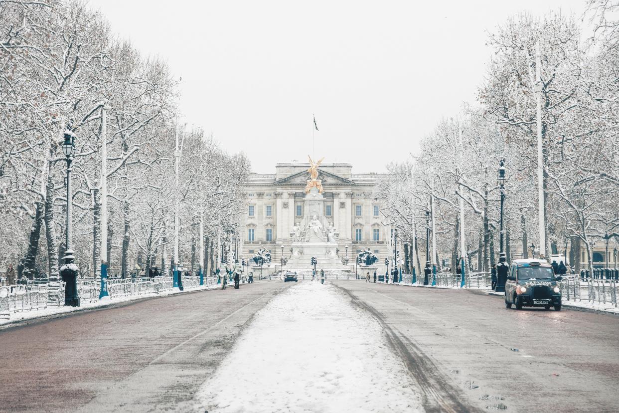 A stunning winter scene of The Mall in London on a snowy day, offering a picturesque view of Buckingham Palace adorned in a pristine blanket of white snow (Getty images)